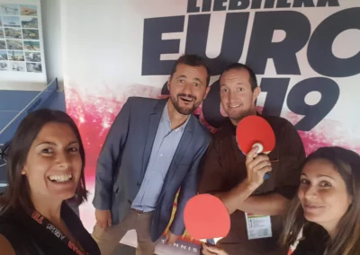 Photo devant le backdrop des partenaires du tennis de table. Euro 2019
